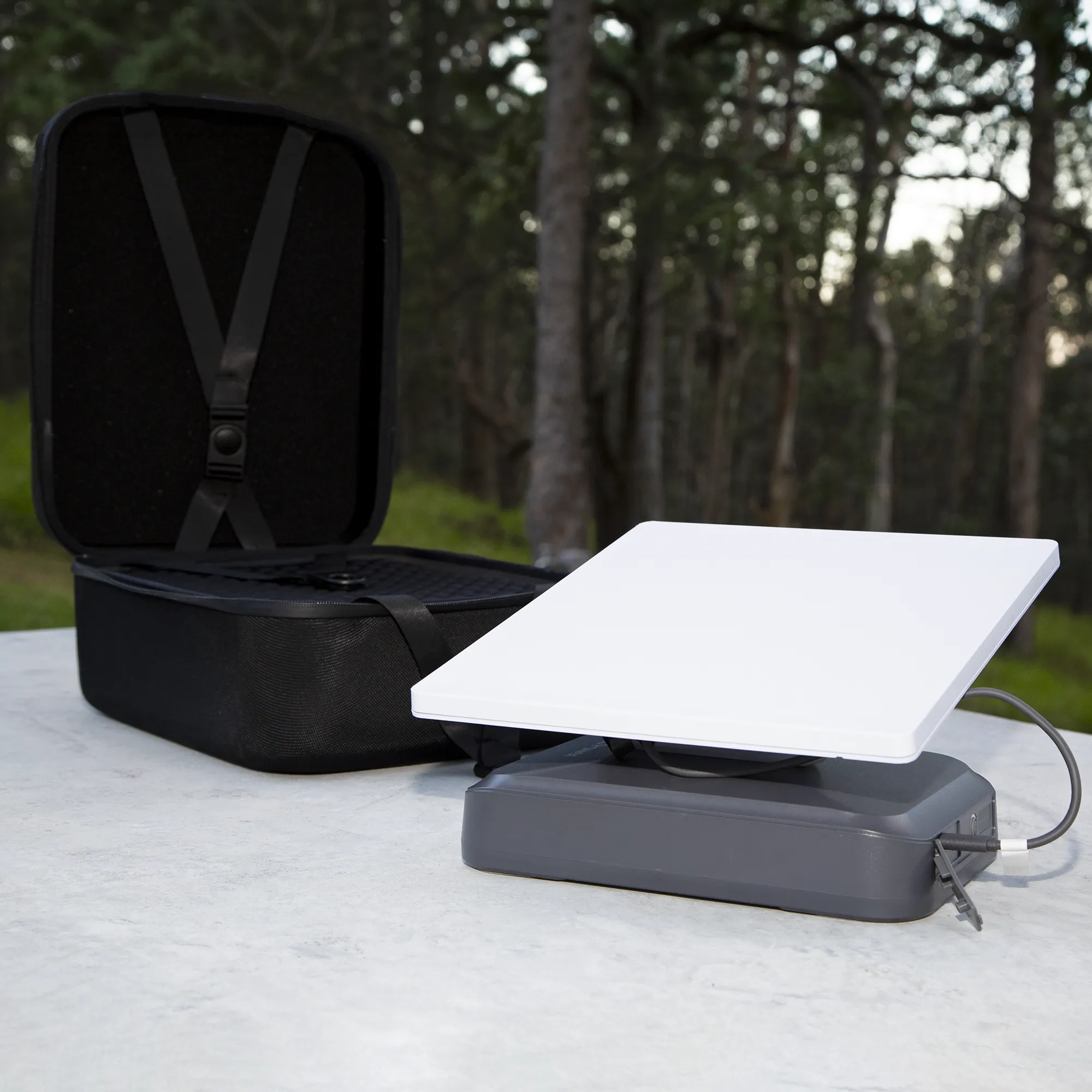 StarGrid 288Wh Starlink Mini battery on a table in tghe outdoors with black protective case open behind it